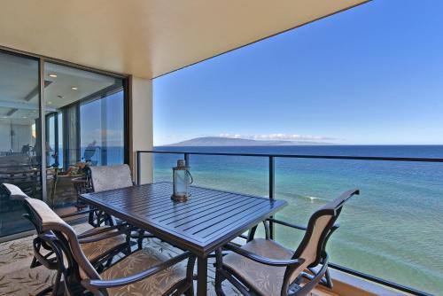 a table and chairs on a balcony with the ocean at Mahana Resort #1204 in Kahana