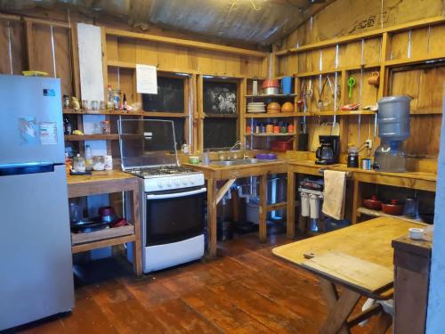 a kitchen with a refrigerator and a stove in it at The Hub - Centro Sakbe in San Juan La Laguna