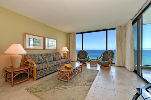 a living room with a couch and some windows at Mahana Resort #906 in Kahana