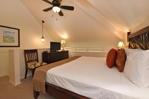 a bedroom with a large bed with a ceiling fan at Maui Kaanapali Villas #B233 in Lahaina