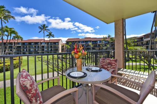 a patio with a table and chairs on a balcony at Papakea #E207 in Kahana