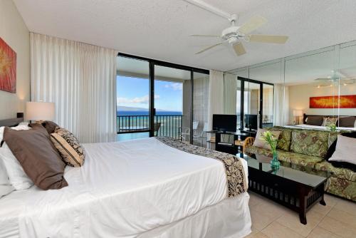 a bedroom with a large white bed and a couch at Valley Isle 1206 in Kahana