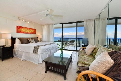a bedroom with a bed and a living room with a couch at Valley Isle 1206 in Kahana