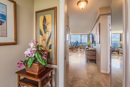a hallway of a home with a vase of flowers on a table at Mahana Resort #1017 in Kahana