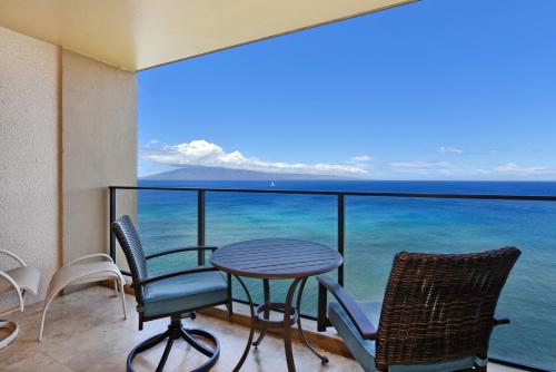 a balcony with a table and chairs and the ocean at Mahana Resort #1205 in Kahana