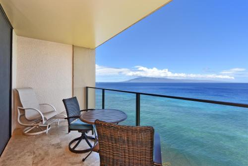 a balcony with a table and chairs and the ocean at Mahana Resort #1205 in Kahana