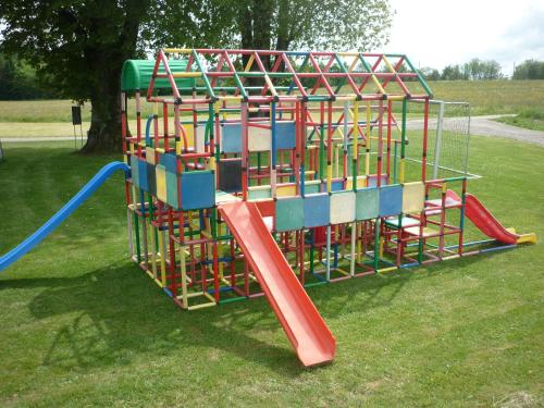 a playground with a colorful play system in a park at La Caquerelle in Col des Rangiers
