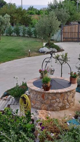 a stone fountain in a garden with flowers and plants at La Campagna di Peppe e Tullia in Formia