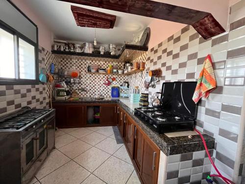 a kitchen with a stove and a counter top at Abou Cristal House 