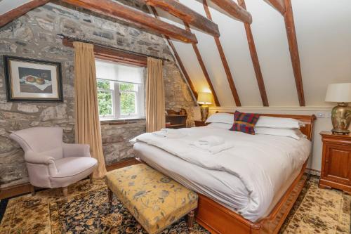 a bedroom with a large bed and a chair at The Polchar - Aviemore in Aviemore