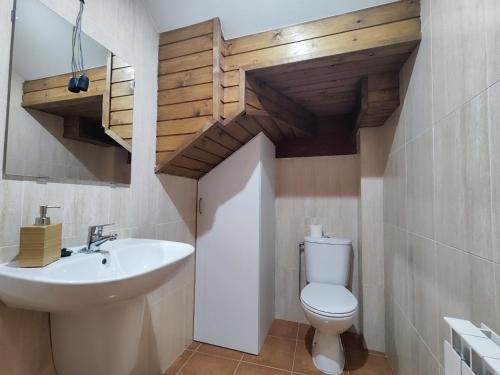 uma casa de banho com um lavatório branco e um WC. em Can Manén em Camprodon