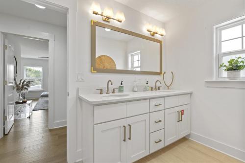 a white bathroom with a sink and a mirror at The White House Island,Beach,Hot Tub,Downtown in Saint Augustine