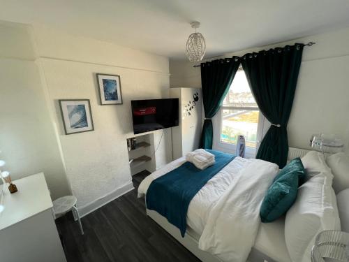 Schlafzimmer mit einem Bett, einem TV und einem Fenster in der Unterkunft Luxury 1Bed Holiday Flat-10 Minutes from London Bridge & 3Mins walk to Lewisham DLR in London