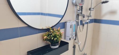 un baño con espejo y una planta en un estante en 1-5Pax Bayu Beach SEAFRONT, FREE BBQ, STEAMBOAT, POOL, WATER SPORT, en Port Dickson