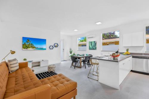 a kitchen and living room with a couch and a table at Up to 16 guests! Modern house near Wynwood in Miami