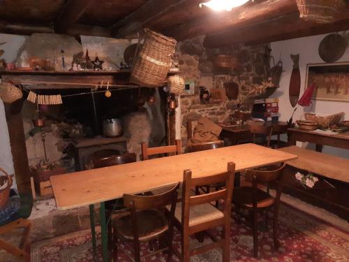 a wooden table and chairs in a room with a fireplace at Cascina Gervasoni in Madonna della Costa