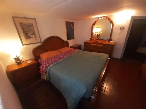 een kleine slaapkamer met een bed en een spiegel bij Cascina Gervasoni in Madonna della Costa