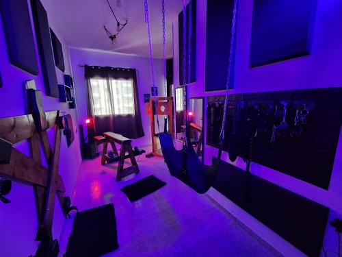 a purple room with a table and chairs in it at Taboo21+ in Ashkelon