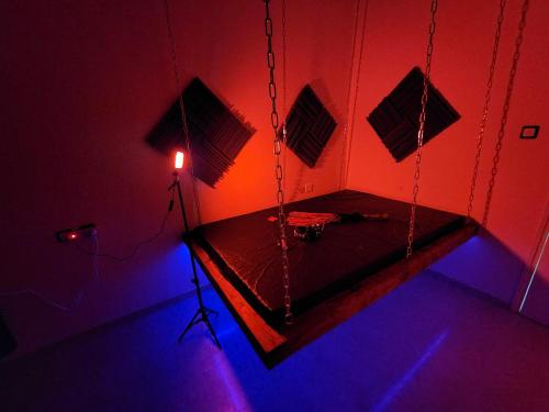 a room with a swingiety with red and blue lights at Taboo21+ in Ashkelon