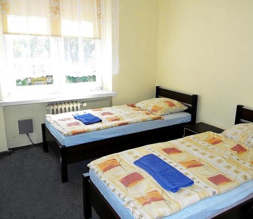 dos camas sentadas una al lado de la otra en una habitación en Pokoje Gościnne Saritas en Katowice