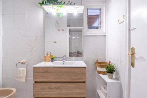 uma casa de banho branca com um lavatório e um espelho em Coastal Paradise & Cozy Home with a 150m from the Beach! em Cambrils