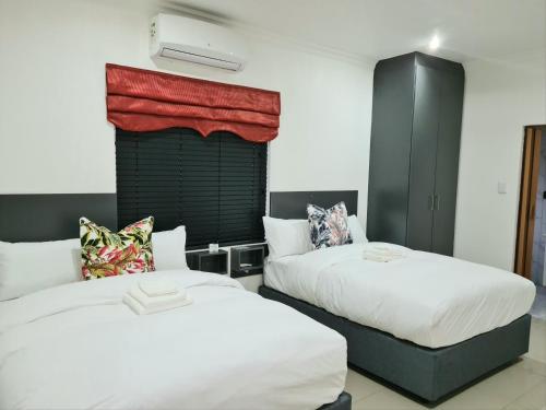 1 Schlafzimmer mit 2 Betten und einem Fenster in der Unterkunft Maison Akiba in Pretoria
