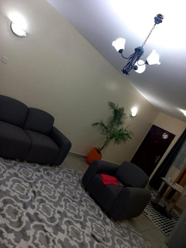 sala de estar con sofá y silla en Brooklyn luxury apartment, en Syokimau