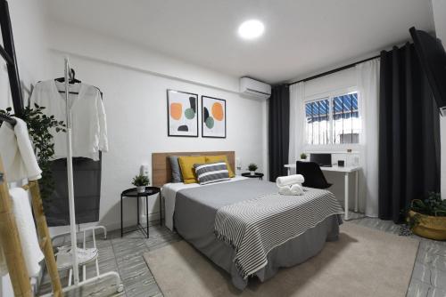 a bedroom with a bed and a desk and a window at Nordik Apartments Village - Arroyo "Rovaniemi" in Benalmádena