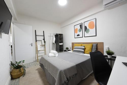 a bedroom with a bed and a desk with a chair at Nordik Apartments Village - Arroyo "Rovaniemi" in Benalmádena