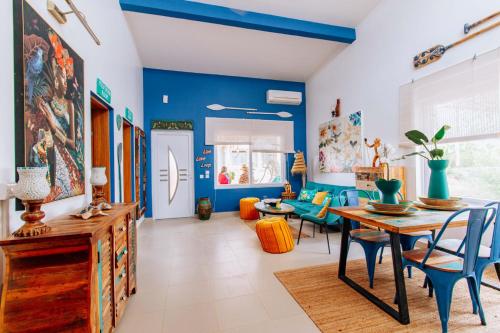 DambaniにあるTipsy Gipsy House, Where the wild things live, 2B Bungalow in Fumba Townの青い壁のダイニングルーム(テーブル、椅子付)