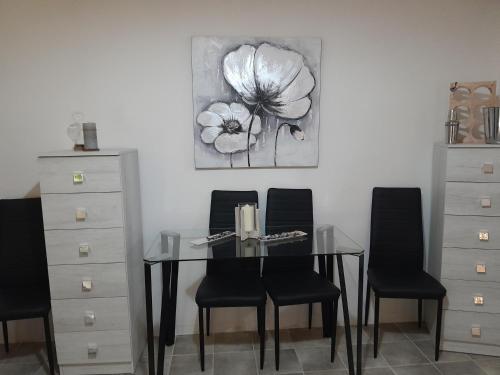 ein Esszimmer mit einem Glastisch und 4 Stühlen in der Unterkunft Casa Relax in Sassari