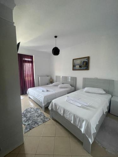 a bedroom with two beds and a window at HOTEL VILA TOSKA in Piskupat