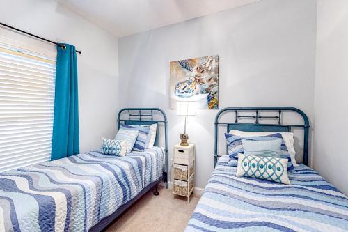 Barefoot Resort في ميرتل بيتش: سريرين في غرفة نوم باللونين الأزرق والأبيض