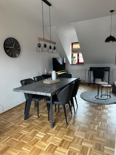 ein Esszimmer mit einem schwarzen Tisch und schwarzen Stühlen in der Unterkunft TraumFerienwohnung "Am Markt" in Pirna - Sächsische Schweiz in Pirna