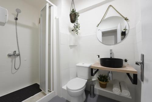 biała łazienka z toaletą i lustrem w obiekcie Nordik Apartments Village - Arroyo "Rovaniemi" w mieście Benalmádena