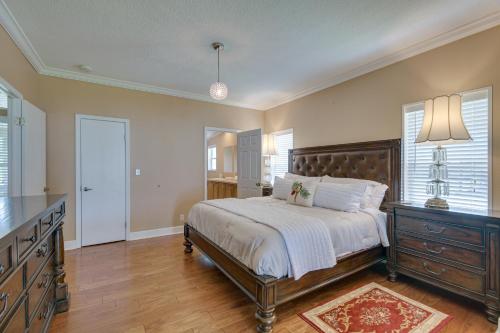 a bedroom with a bed and a dresser and windows at Waterfront Georgetown Retreat on Lake George! in Georgetown