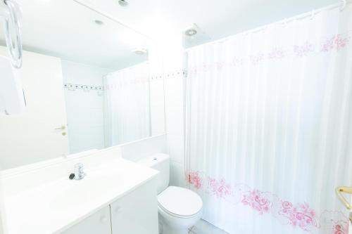 biała łazienka z toaletą i umywalką w obiekcie Oceana Suites Eurovista w mieście Viña del Mar