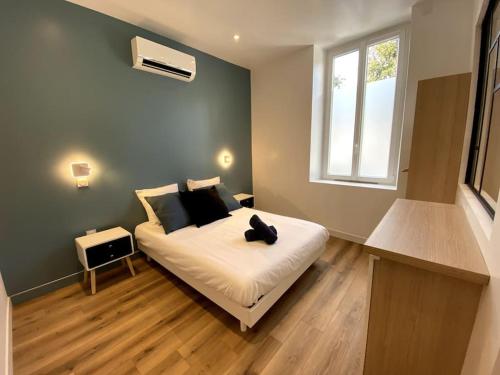 a bedroom with a bed with a cat sitting on it at LA PERLE BLEUE, Centre ville Valence,Proche gare in Valence