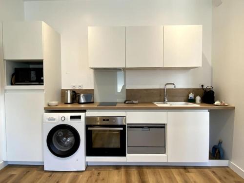 une cuisine avec un lave-linge et un lave-vaisselle dans l'établissement LA PERLE BLEUE, Centre ville Valence,Proche gare, à Valence