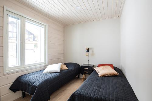two beds in a room with two windows at Luxury Villa BestVillas Himos in Himos