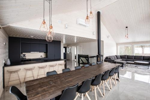 a large wooden bar in a room with chairs at BestVillas Himos Finland in Jämsä
