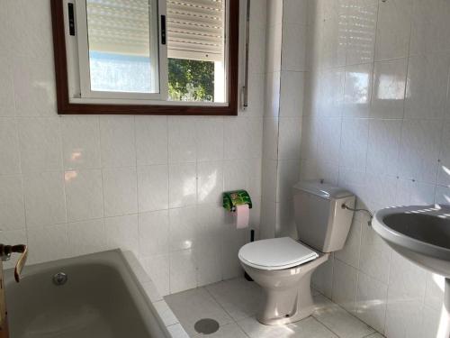 La salle de bains est pourvue de toilettes, d'un lavabo et d'une baignoire. dans l'établissement Casa Areabrava playa, à Pontevedra