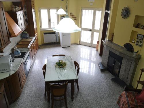 een keuken met een tafel met stoelen en een open haard bij Casa Manzoni Abriola in Abriola