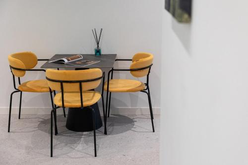 uma mesa preta com cadeiras amarelas num quarto em Nimar Suite em Formia