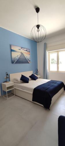 a bedroom with a large bed with a blue wall at Manzoni 159 in Naples