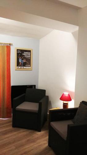 - un salon avec deux chaises et une table avec une lampe dans l'établissement Les Petits Conforts, à Carcassonne