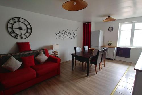 un salon avec un canapé rouge et une table dans l'établissement Les Petits Conforts, à Carcassonne