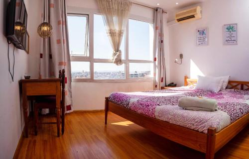a bedroom with a bed and a window and a desk at Radama Hotel in Antananarivo