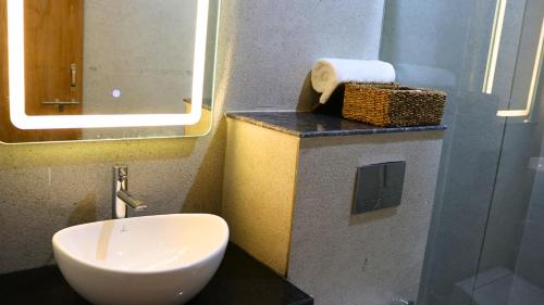 a bathroom with a toilet and a sink and a mirror at AVA Hotels and Corporate Suites in Gurgaon