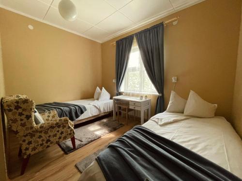 a room with two beds and a chair and a window at Paide B&B in Paide